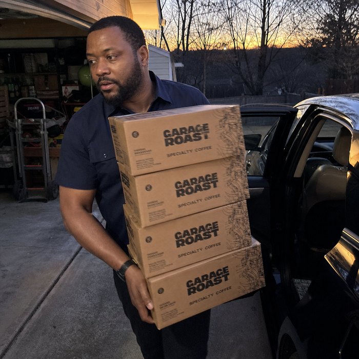 Seller carrying boxes of Garage Roast coffee